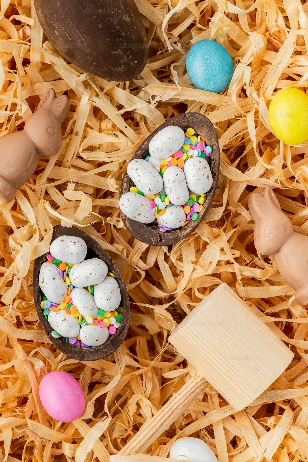 a pile of fake eggs sitting on top of a pile of fake grass