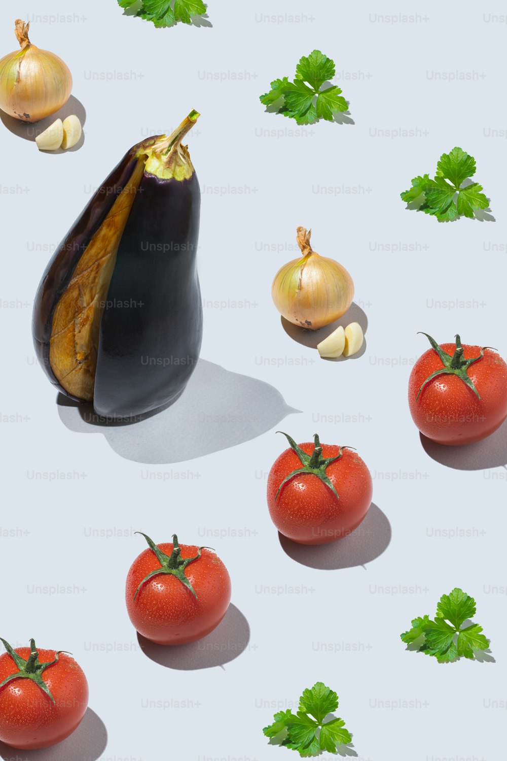 a group of tomatoes and garlic on a white surface