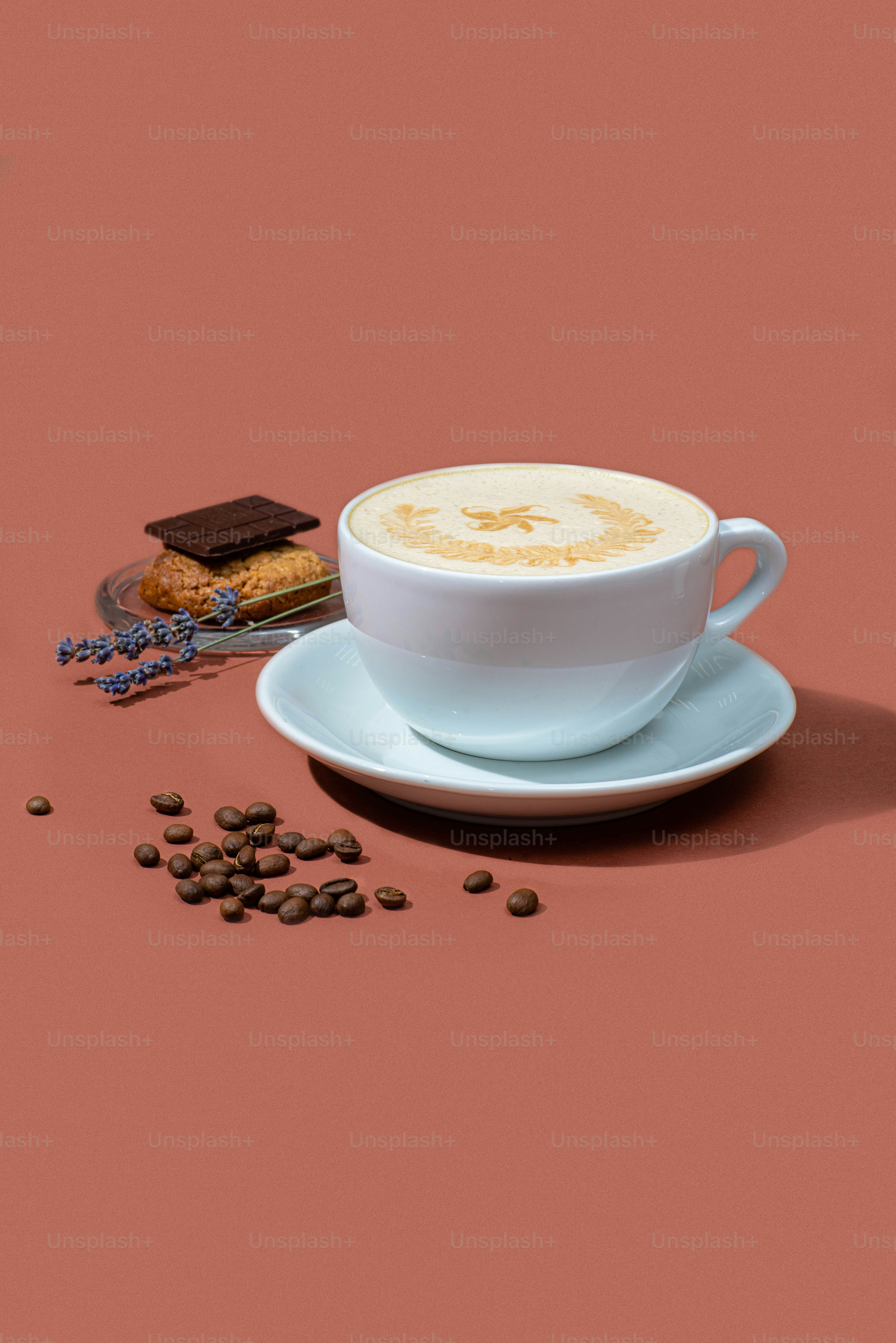 ピンクの背景にカプチーノのカップとクッキーのプレート