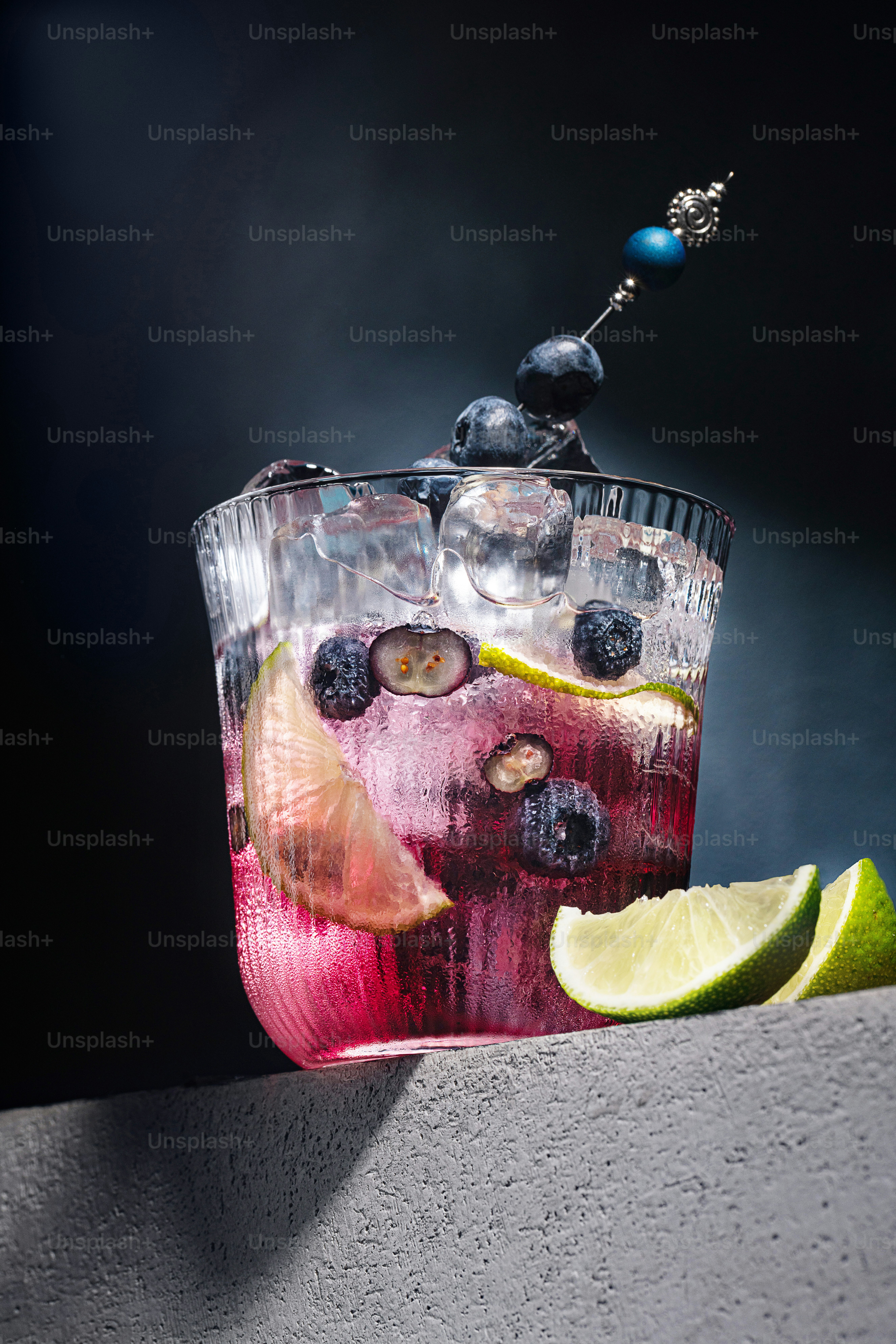 a pitcher of liquid with fruit and a lemon wedge