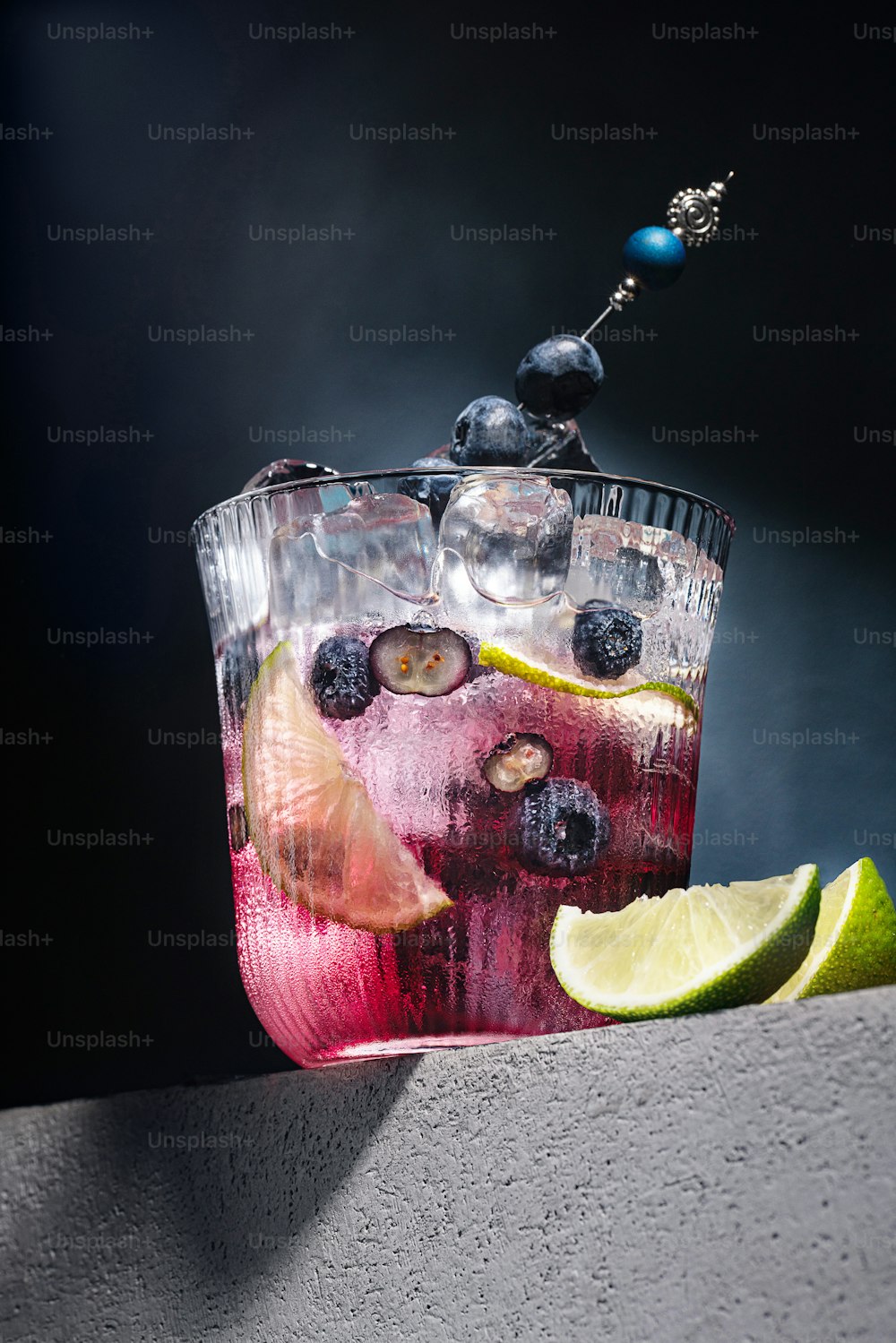 a pitcher of liquid with fruit and a lemon wedge