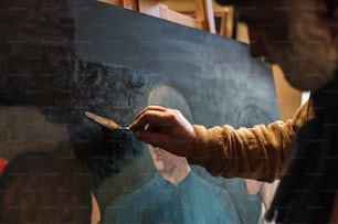Un homme peint un tableau sur une toile