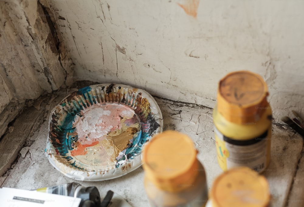 a plate with some paint on it next to some paintbrushes