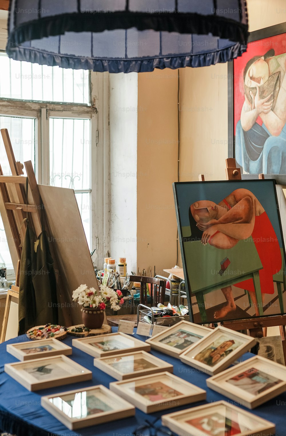 uma mesa azul coberta com quadros e pinturas