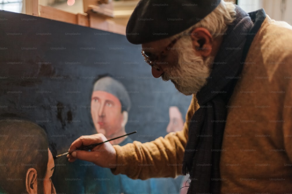 un homme peignant un tableau d’un homme avec une barbe