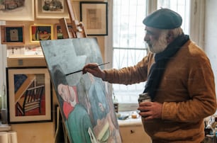 Un hombre está pintando sobre un lienzo en una habitación