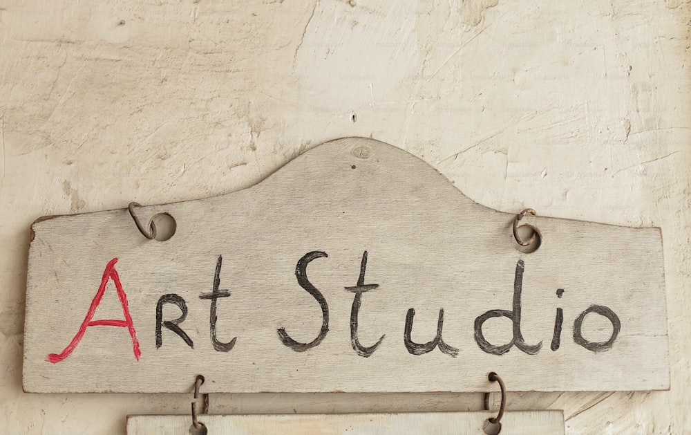 a sign that says art studio hanging on a wall