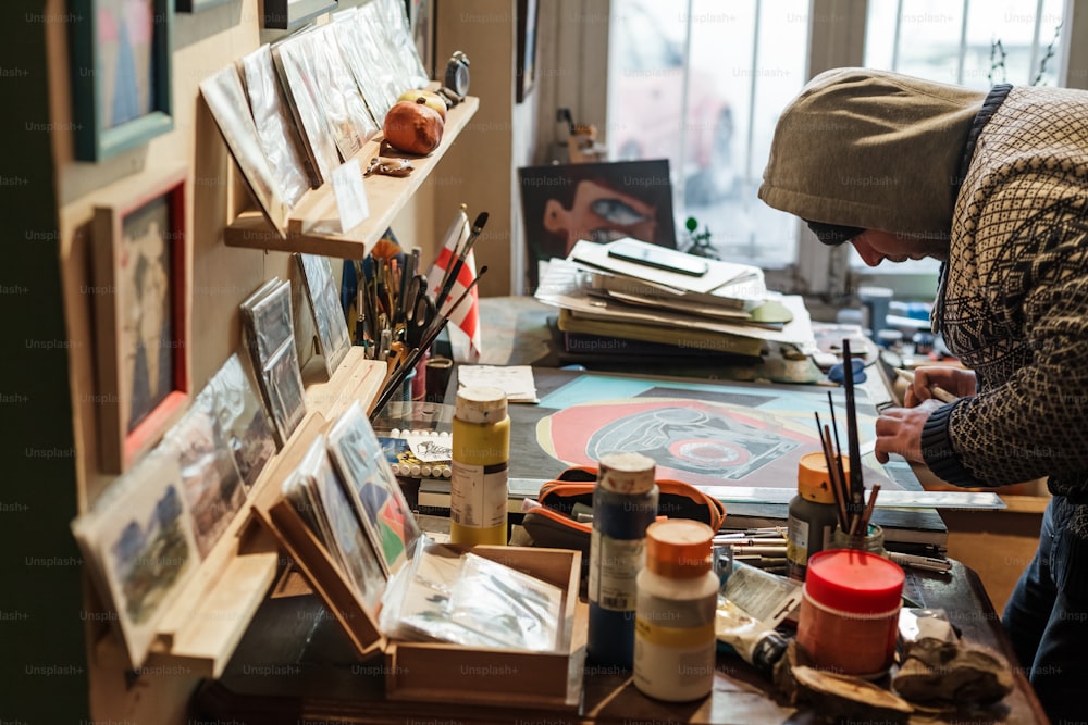 um homem está pintando em uma tela em um estúdio