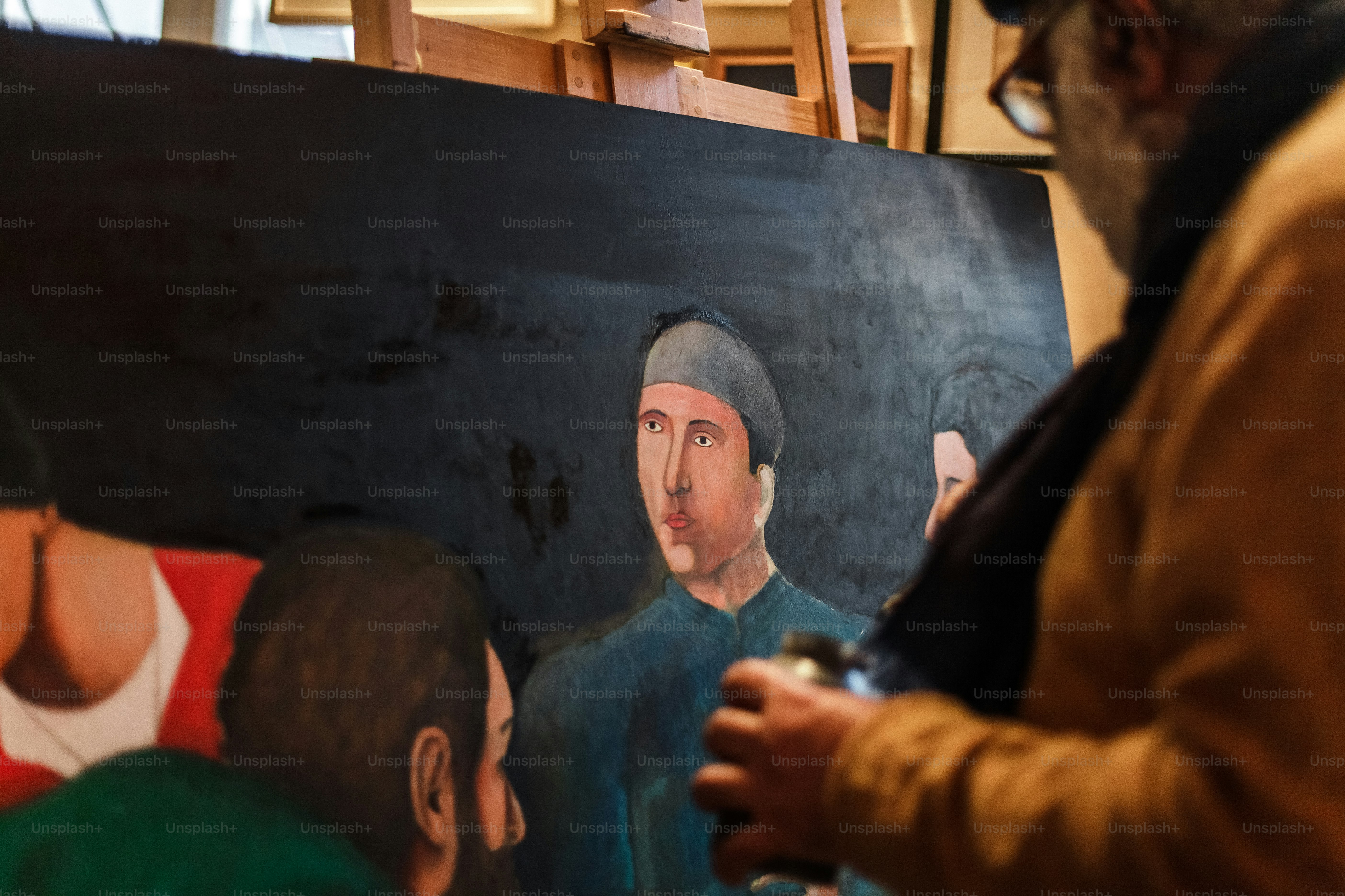 Foto Un hombre parado frente a una pintura de un hombre – Cuadro Imagen ...