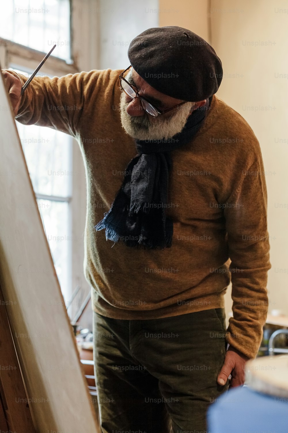 a man in a brown sweater and a black scarf