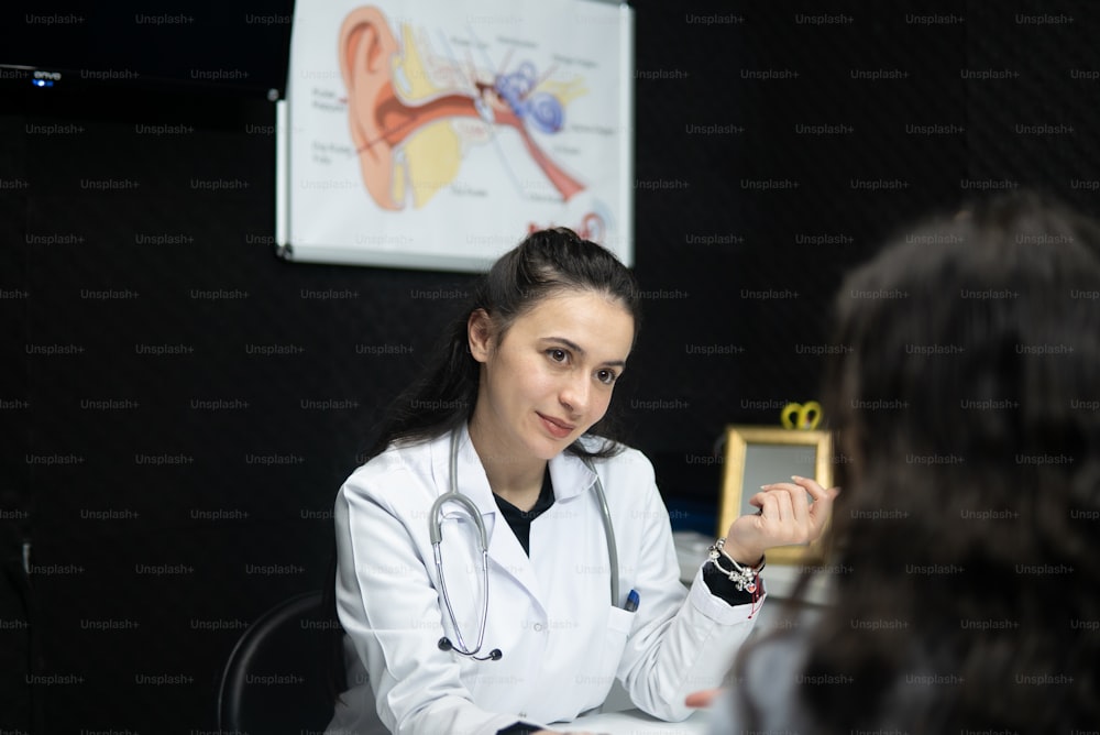 a woman in a white coat sitting at a table