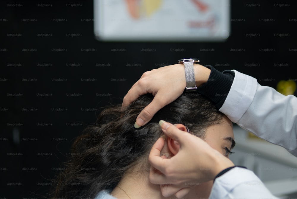 uma mulher recebendo seu cabelo estilizado por um cabeleireiro