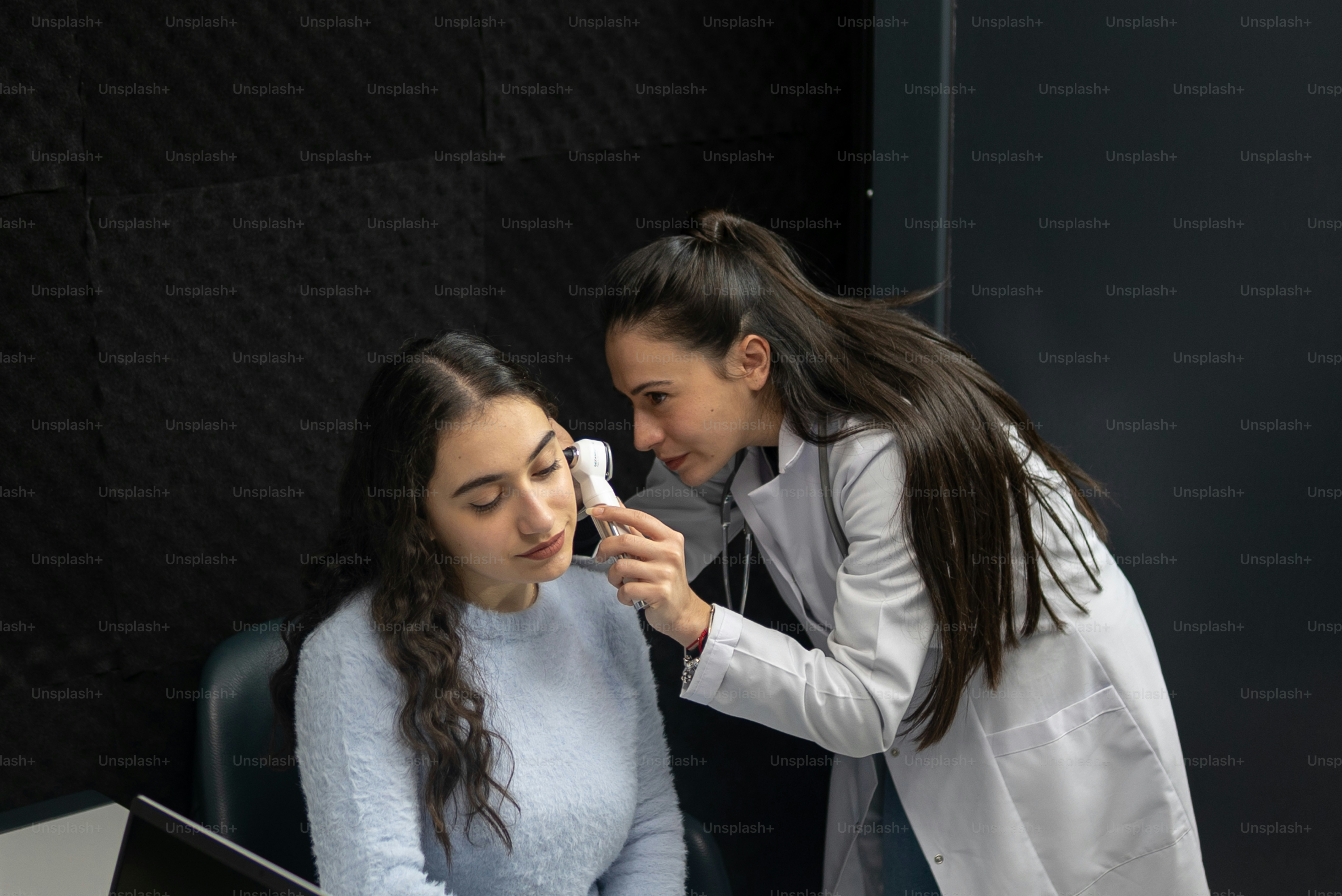 흰색 실험실 코트를 입은 두 여성이 컴퓨터 화면을 보고 있다