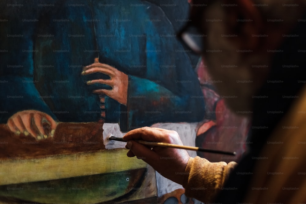 Un homme peint un tableau avec un pinceau