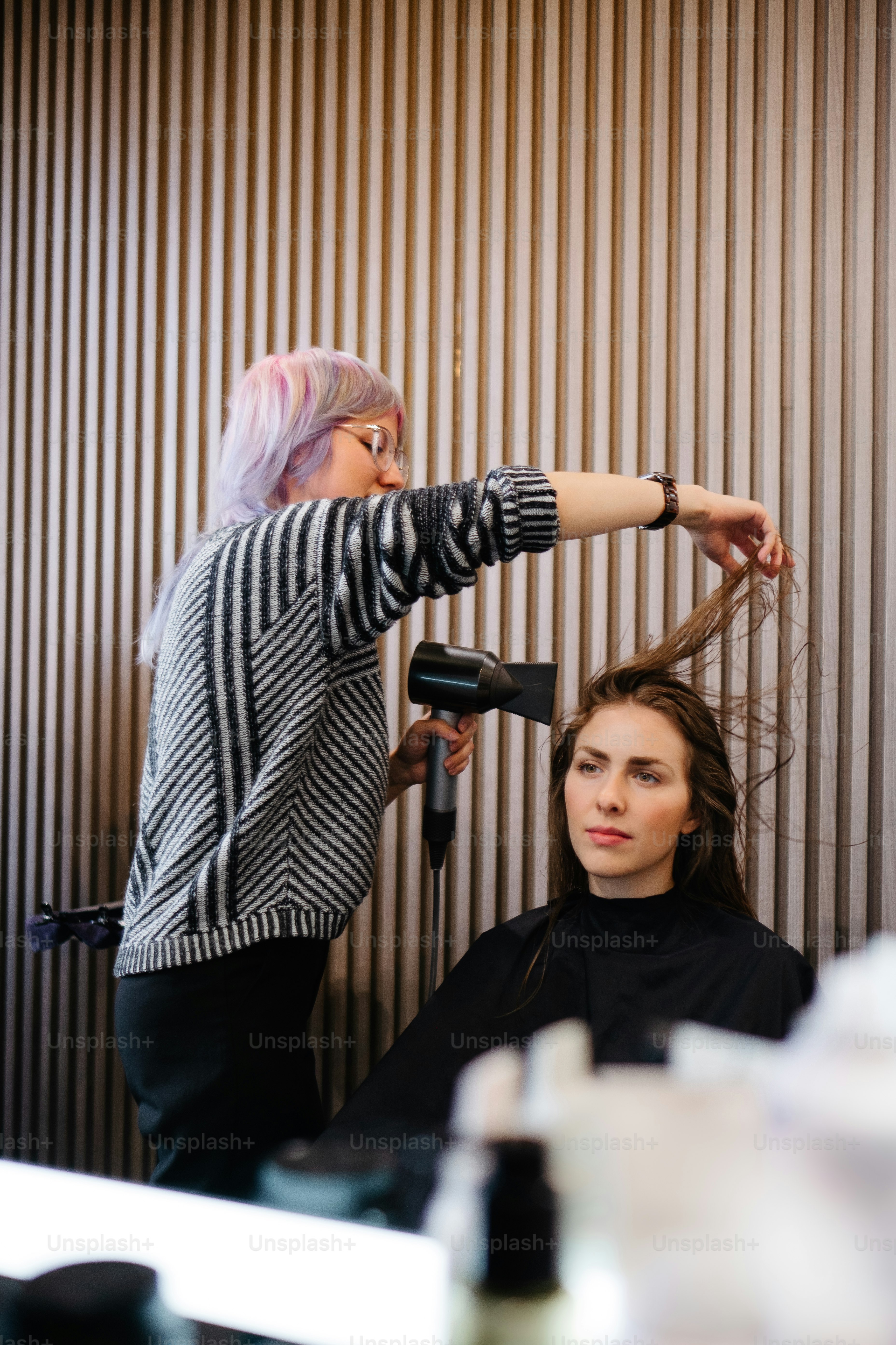 a woman blow drying another woman's hair