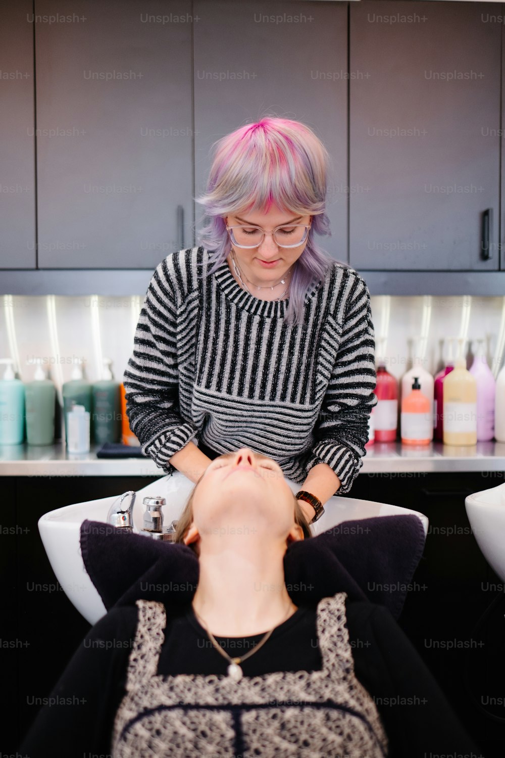 a woman getting a haircut at a salon