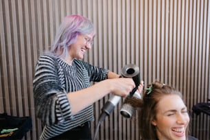 Una donna che si fa acconciare i capelli da un parrucchiere