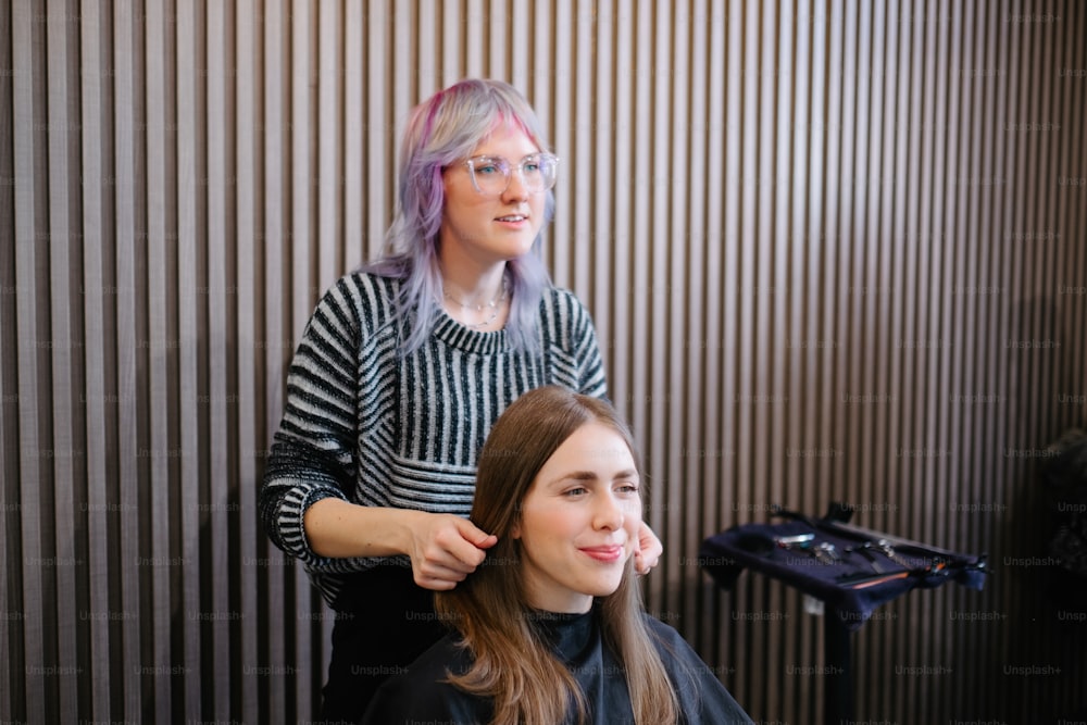 ヘア��スタイリストに髪を切られる女性
