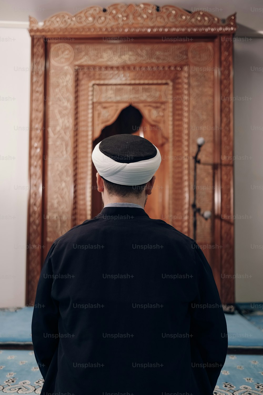 um homem em pé na frente de uma porta de madeira
