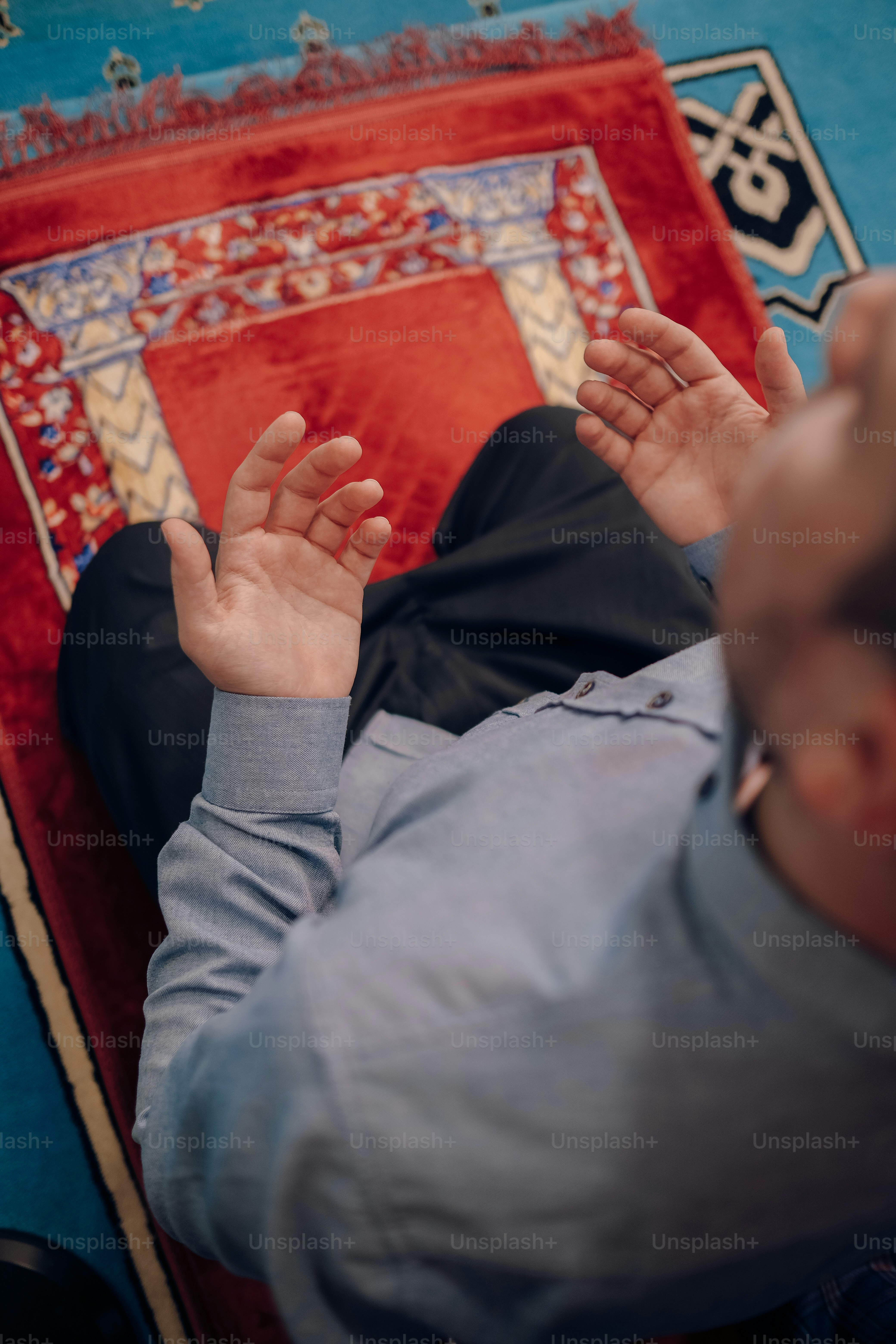 Un uomo sdraiato su un tappeto con le mani alzate