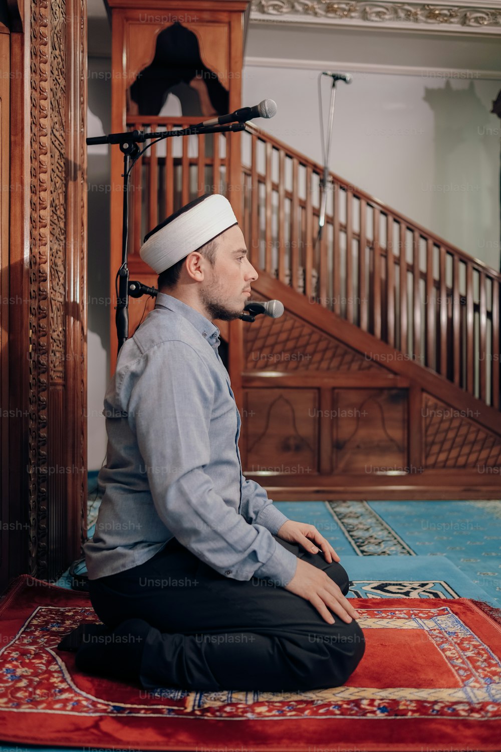 a man sitting on a rug with a pipe in his mouth