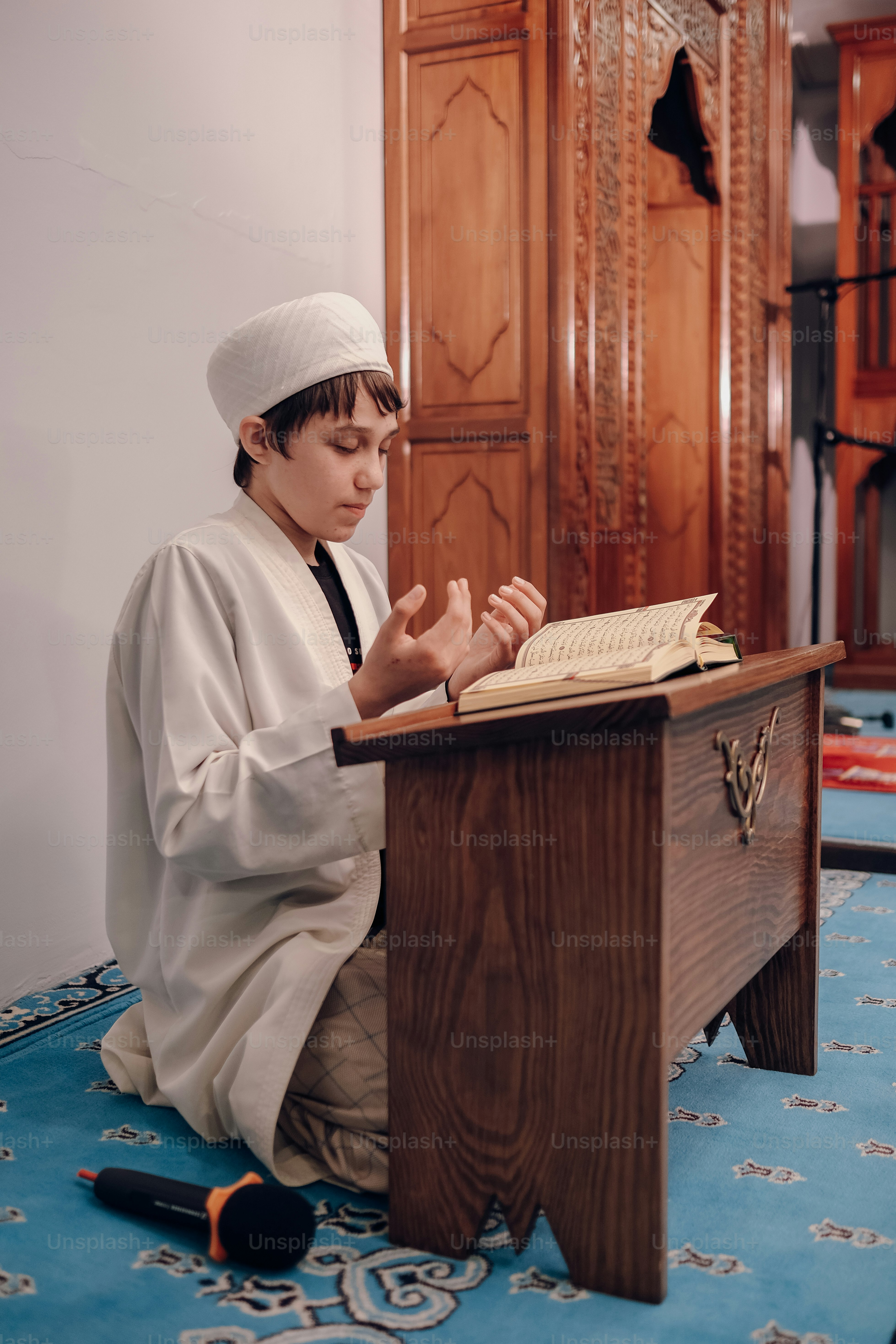a young boy sitting at a table with a book