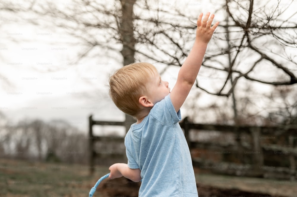 um menino segurando um frisbee azul em sua mão