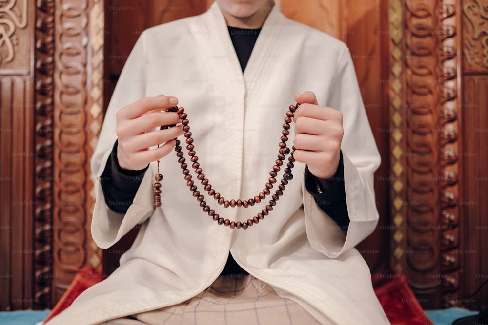 Un uomo vestito da sacerdote che tiene un rosario