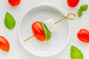 a white plate topped with tomatoes and cheese