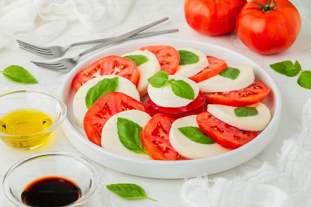 a plate of tomatoes and mozzarella with olive oil