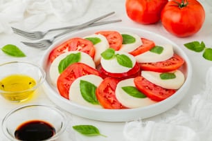 un piatto di pomodori e mozzarella con olio d'oliva