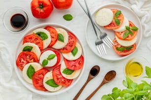 a white plate topped with sliced tomatoes and sliced mozzarella