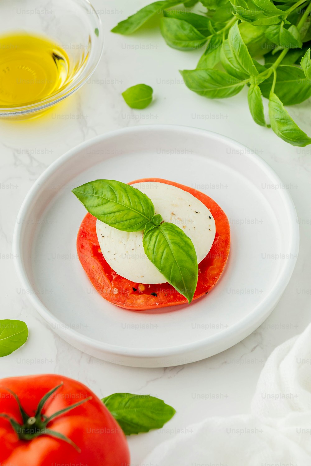 un plato blanco cubierto con tomate y queso