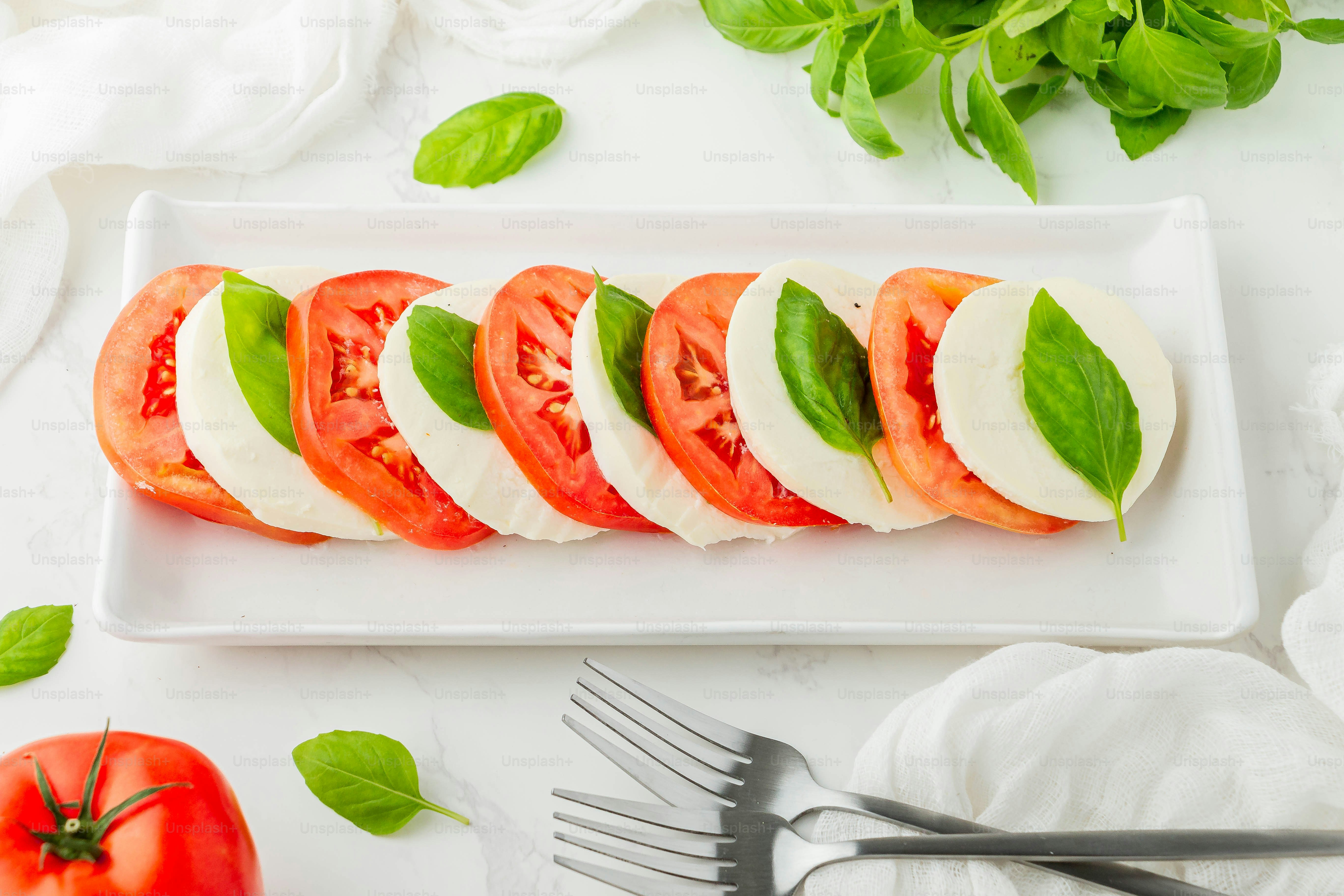 in Scheiben geschnittene Tomaten und Mozzarella auf einem weißen Teller