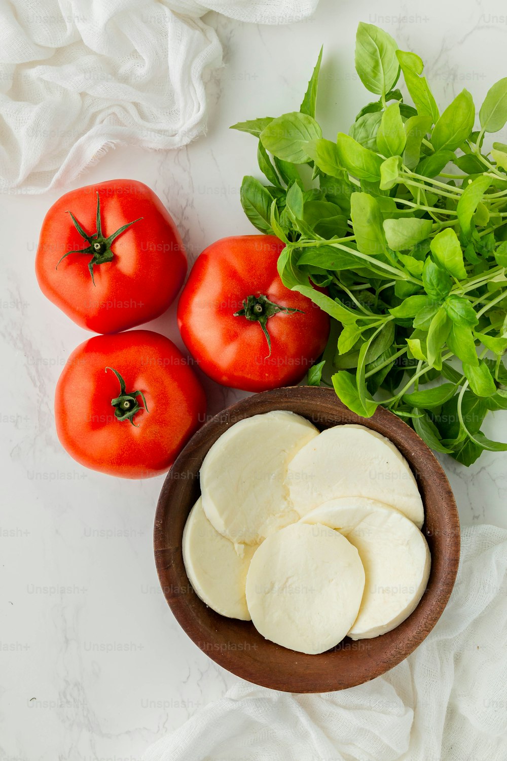 a bowl of mozzarella and tomatoes on a table