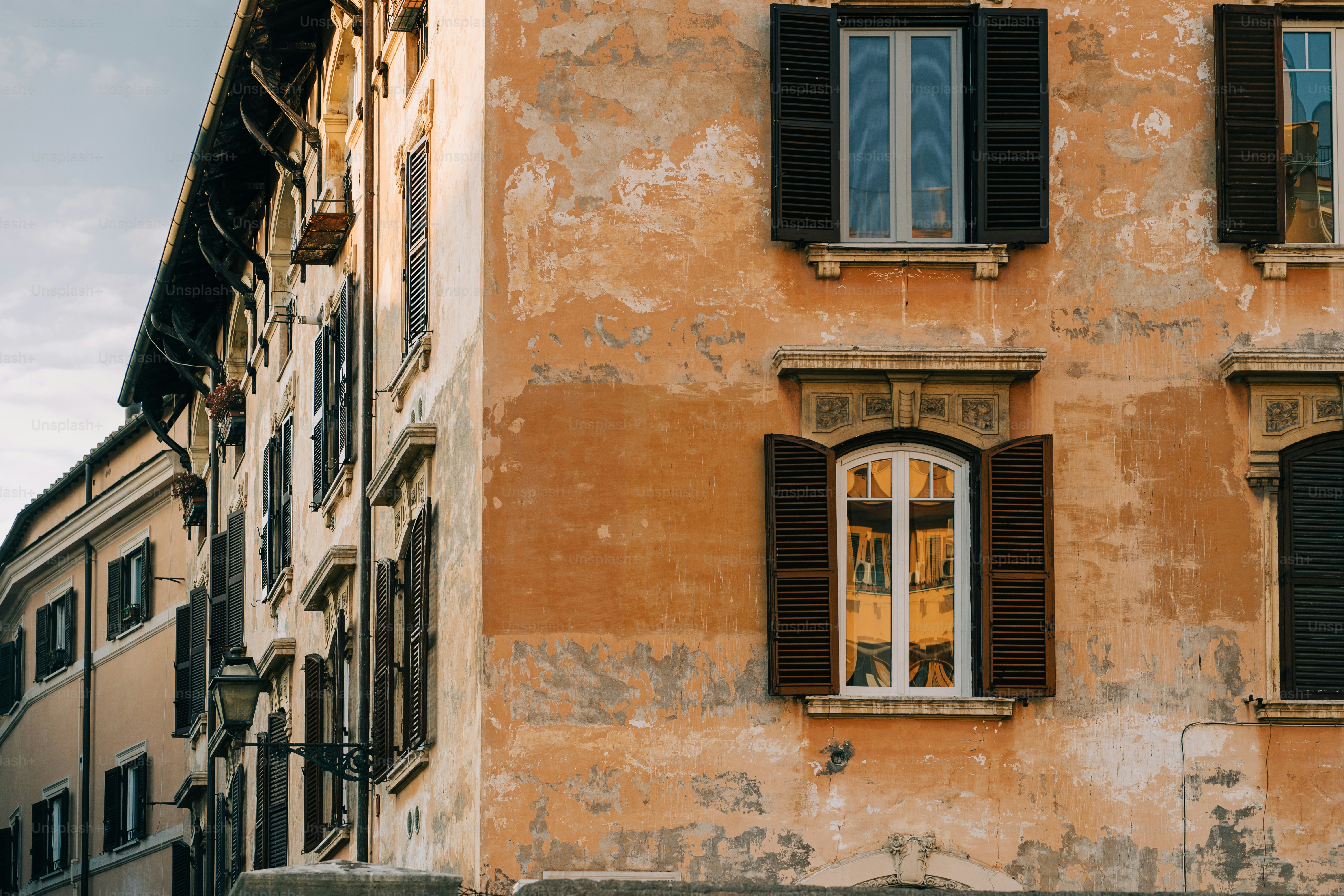 an old building with two windows and shutters
