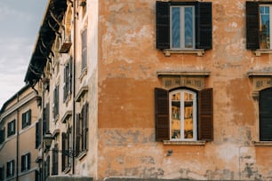 Un vecchio edificio con due finestre e persiane