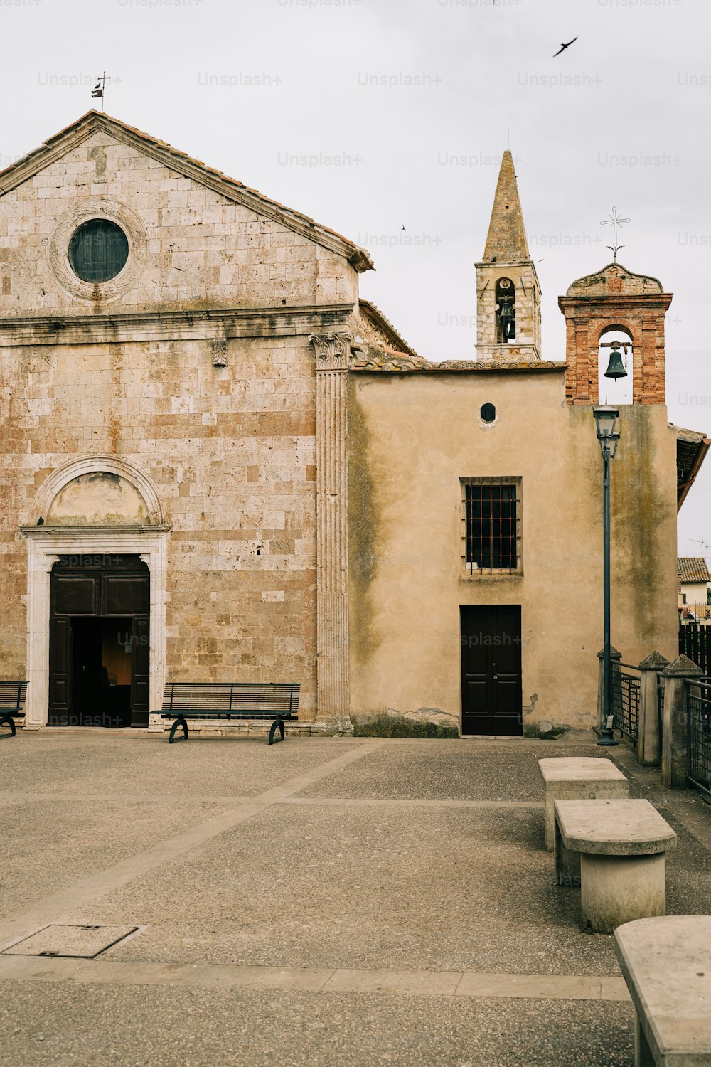 an old church with benches in front of it