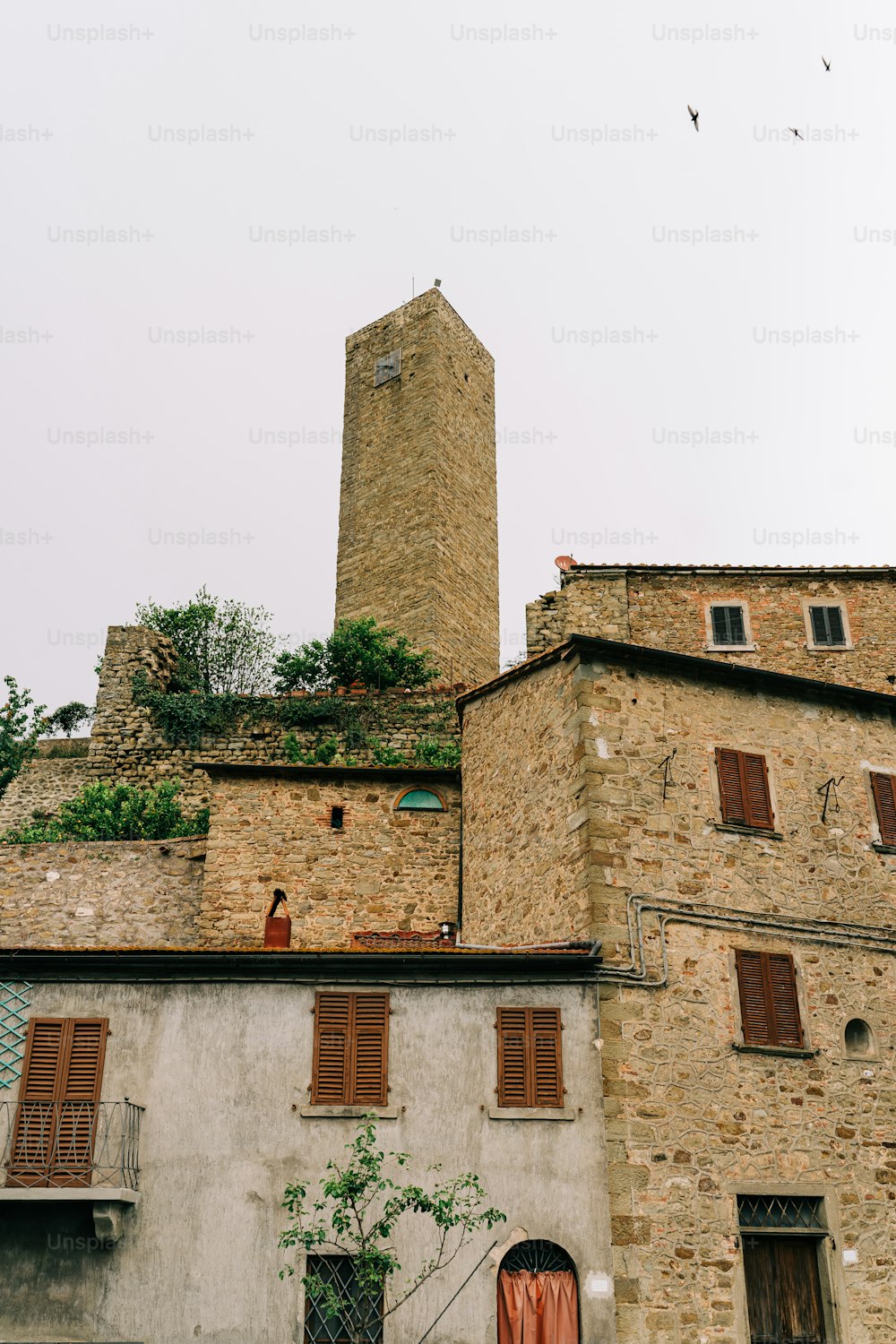 Un alto edificio in mattoni con una torre dell'orologio sullo sfondo