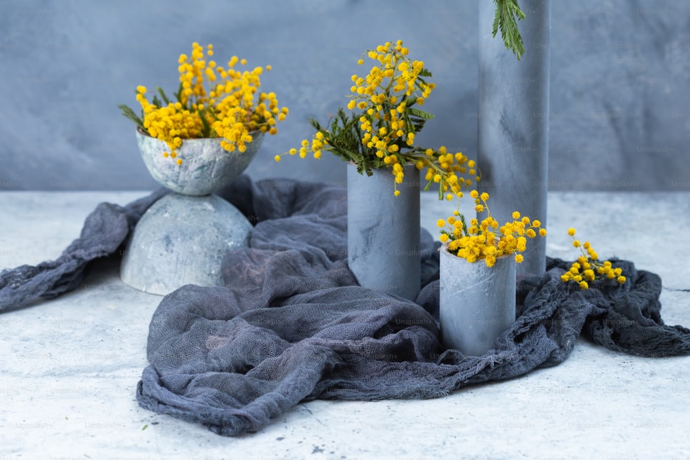 three vases filled with yellow flowers on top of a table