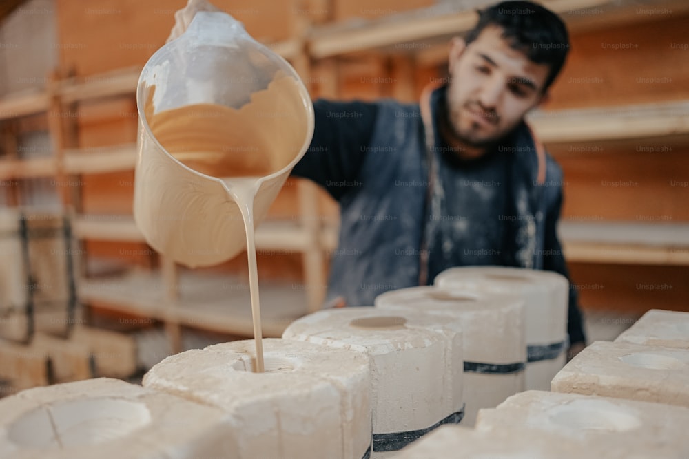 a man is pouring something into a container