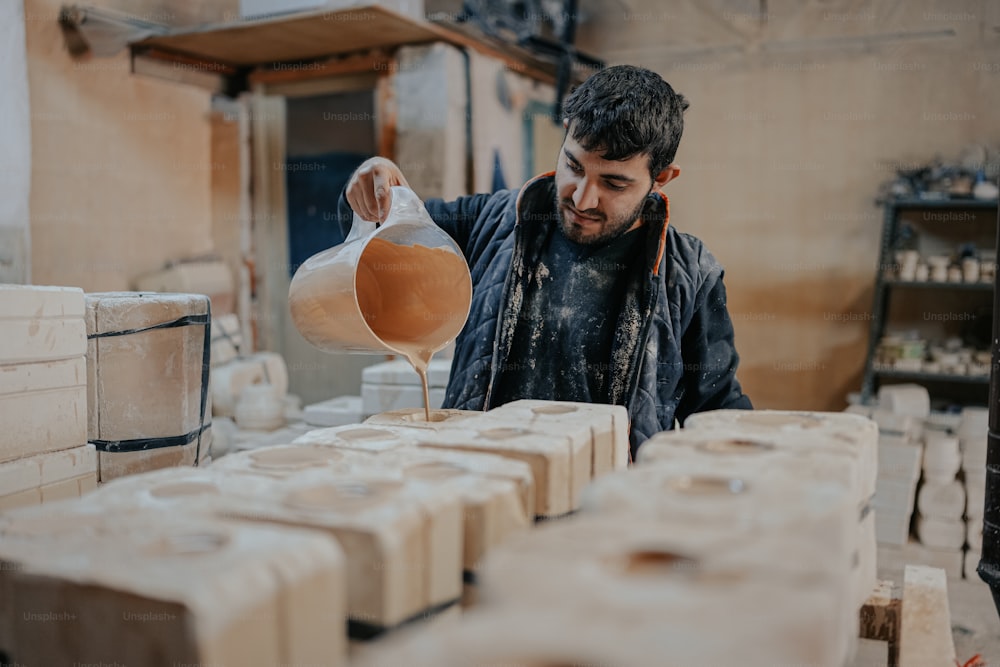 a man is pouring something out of a jug