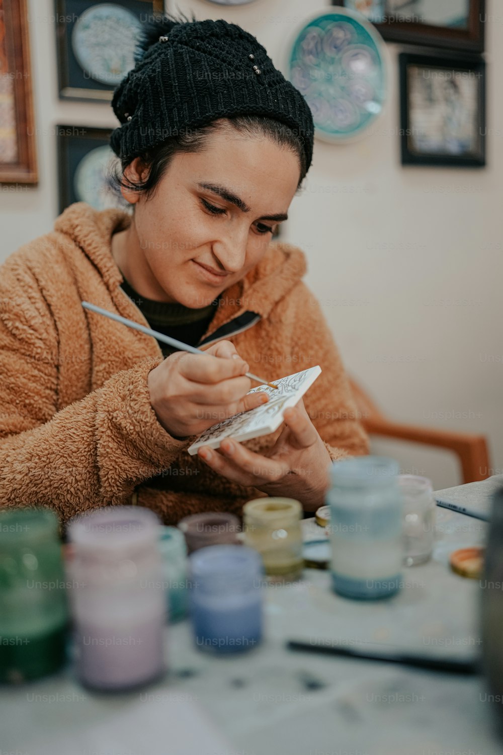 Une femme est assise à une table en train de peindre
