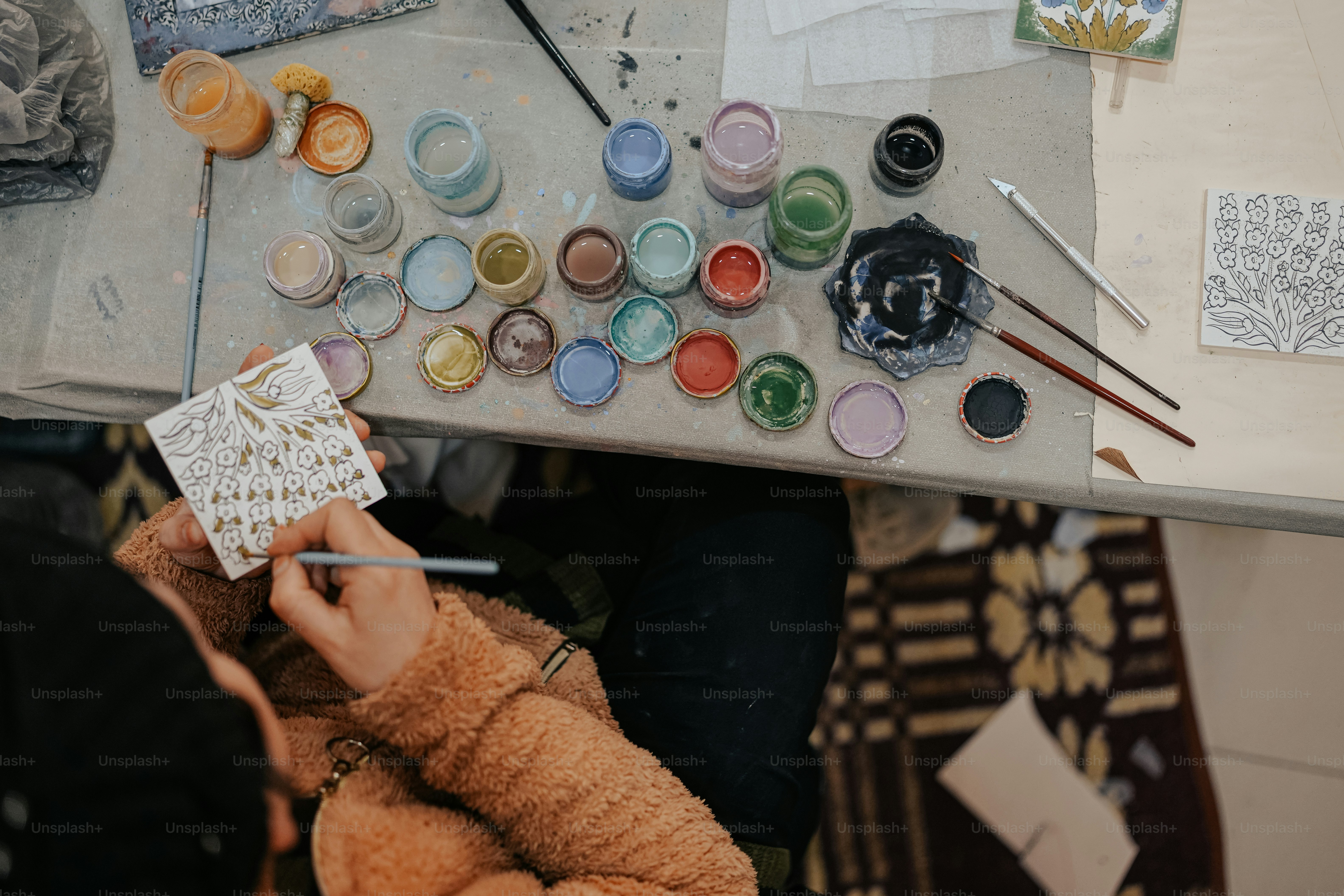 Una mujer está pintando un cuadro en una mesa