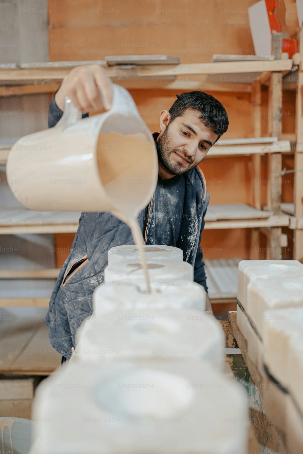 a man pouring a jug of liquid into a container