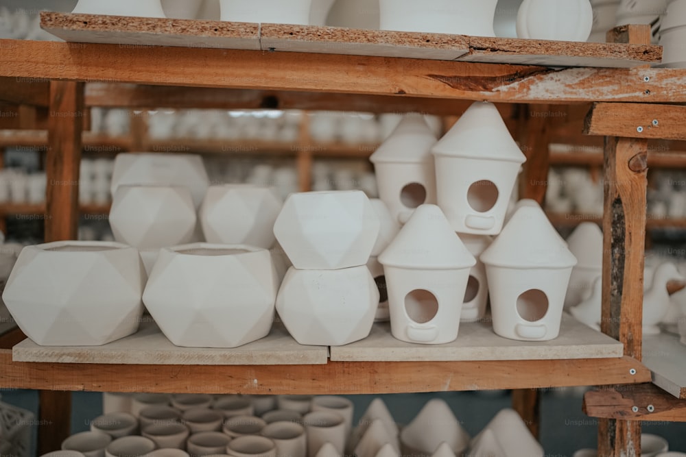 a shelf filled with lots of white vases
