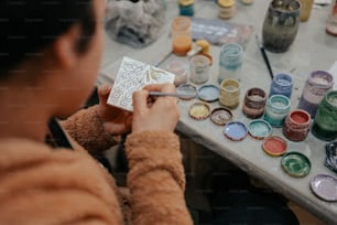 a person painting a picture on a table