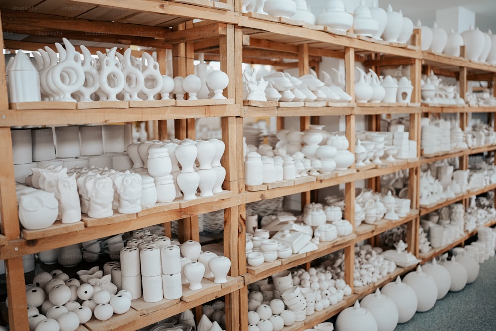 Un estante lleno de muchos jarrones blancos