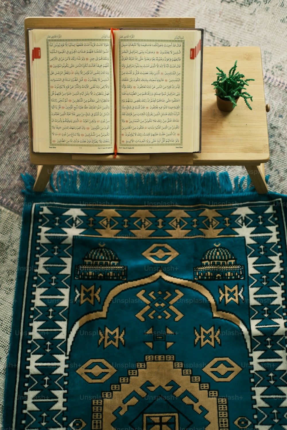 Un libro abierto sentado encima de una alfombra azul