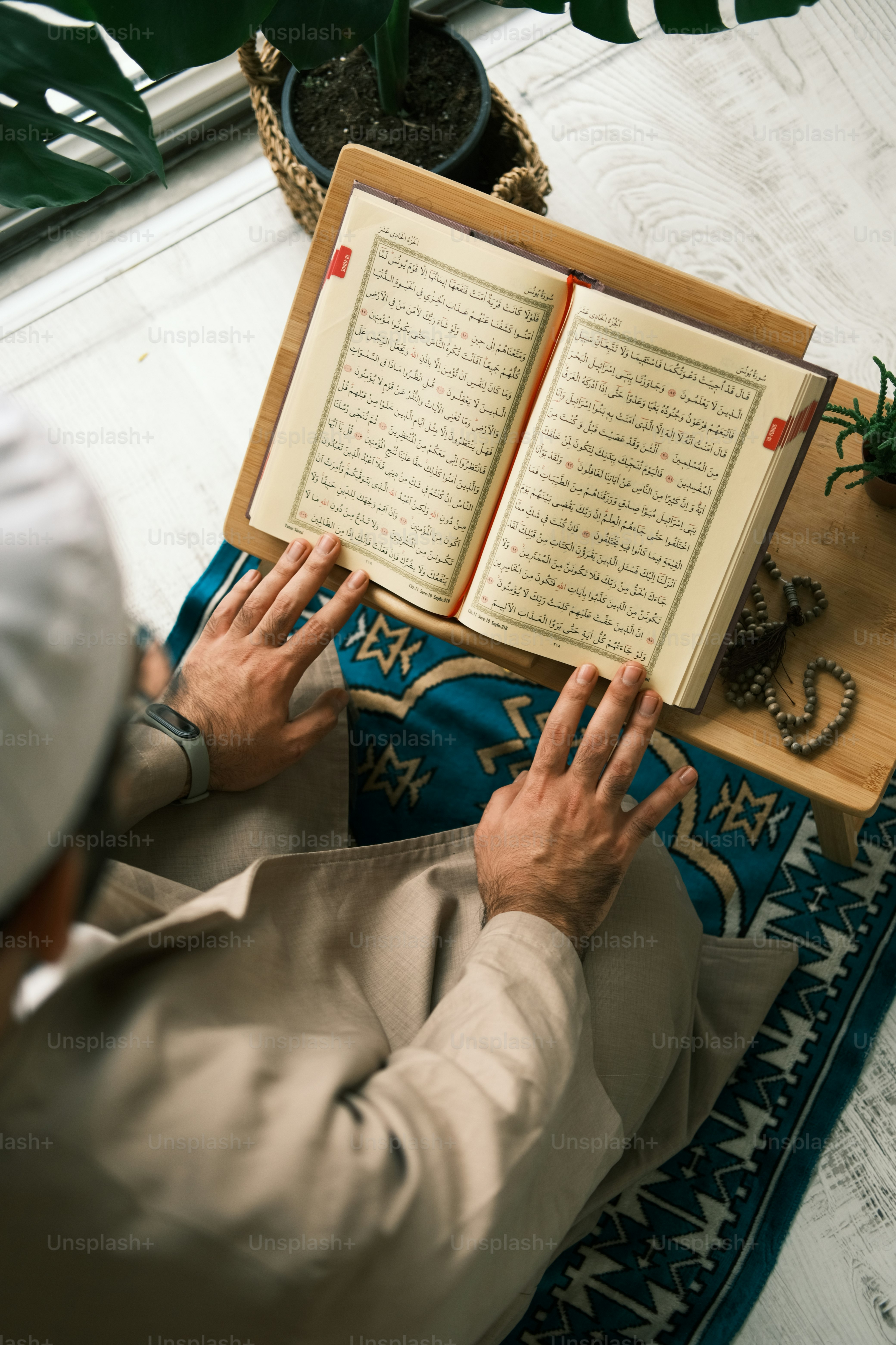a man sitting on a rug reading a book